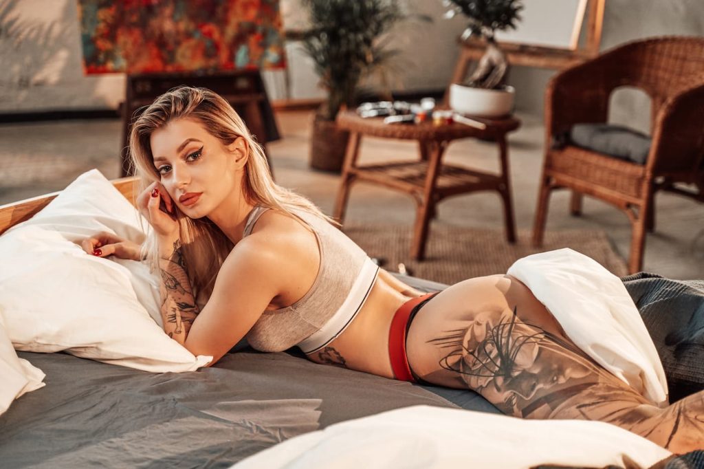 Sexy blonde woman with tattoo on leg.